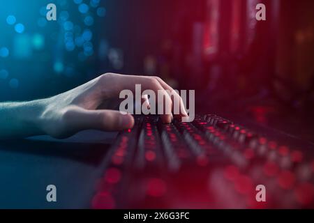 Hände, Neon und Tippen auf dem Computer mit Spieltastatur zu Hause für E-Sport, Internet oder Videoaufnahmen. RGB-Licht, pc und Person auf Schlüssel am Tisch für Stockfoto