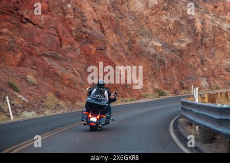 Motorradtour durch Amerika. Ein paar Radfahrer fahren auf dem Highway vor dem Hintergrund der Felsen, Blick nach hinten. Nicht erkennbare Biker auf einem Motorrad Stockfoto