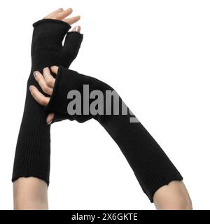 Anmutige weibliche Hände in langen schwarzen, fingerlosen Handschuhen aus Wolle mit Fäustlingen auf weißem Hintergrund Stockfoto