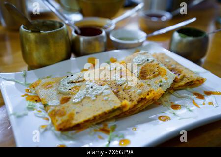 Nahaufnahme eines Tellers voller köstlicher hausgemachter indischer Masala Dhosa Gerichte mit Chutney-Saucen auf einem Restauranttisch. Klassisches südindisches Essen Stockfoto