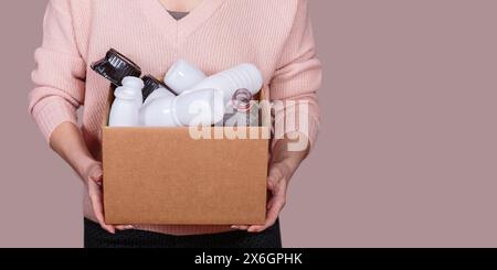 Frau hält Pappkarton mit Plastikabfällen Stockfoto