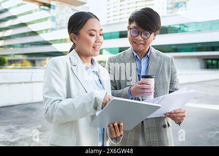 Professionelle Kollegen arbeiten während der Kaffeepause in der Stadt im Freien zusammen Stockfoto
