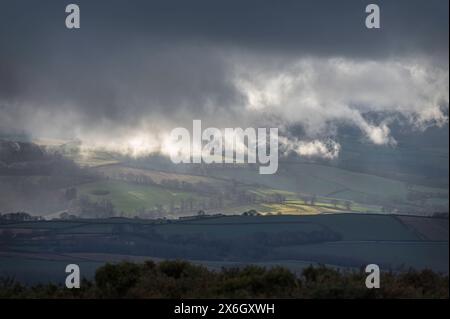 Blick von den Quantock Hills in Somerset, England, Großbritannien, mit Blick auf Exmoor, während die Sonne durch die Wolken bricht und die Landschaft beleuchtet Stockfoto