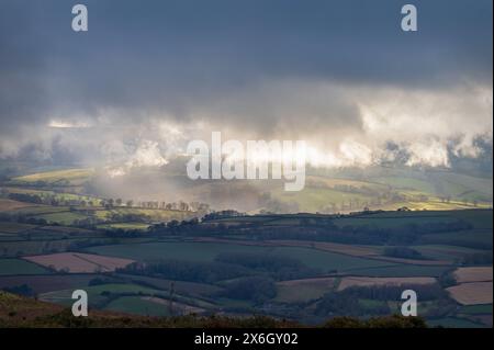 Blick von den Quantock Hills in Somerset, England, Großbritannien, mit Blick auf Exmoor, während die Sonne durch die Wolken bricht und die Landschaft beleuchtet Stockfoto