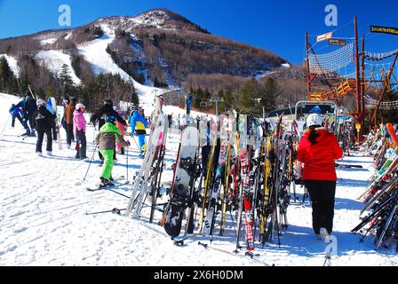 Eine Skifahrerin legt ihre Skier an einem Wintertag in Hunter New York während einer Pause von der Piste an einem Gepäckträger ab Stockfoto