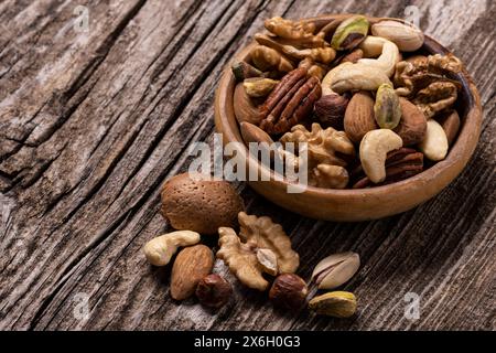 Verschiedene getrocknete Früchte in der Schüssel und auf dem alten Holztisch in extremer Nahaufnahme. Stockfoto
