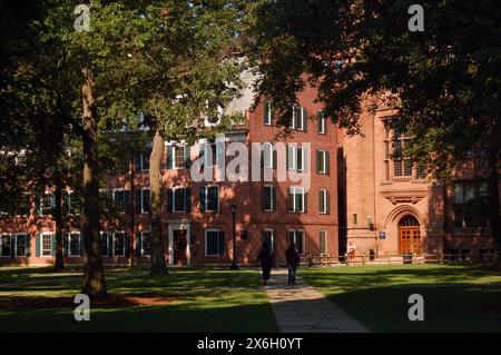 Zwei Studenten laufen in der Nähe der historischen Connecticut Hall auf dem imposanten Ivy League Campus der Yale University in. New Haven, Connecticut Stockfoto