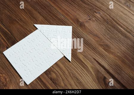 Nahaufnahme einer Wohnung aus Puzzleteilen isoliert auf hölzernem Hintergrund mit Kopierraum. Stockfoto