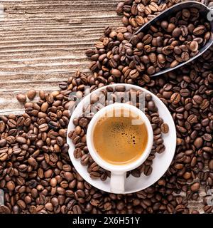 Blick von oben auf eine Tasse italienischen Espresso mit gerösteten Kaffeebohnen auf rauem Holzhintergrund. Leerer Bereich Stockfoto