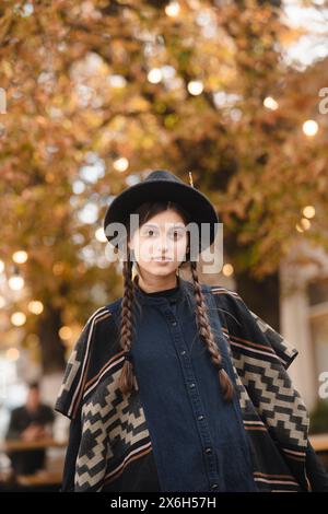 Eine modische junge Frau, elegant in Schwarz gekleidet mit einem Hut. Stockfoto