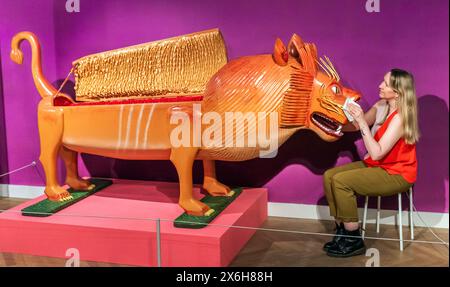 Kat Baxter, Kurator der Archäologie, reinigt einen löwenförmigen Sarg, der vom weltberühmten ghanaischen Sargenschreiner Paa Joe hergestellt wurde, der für seine Schnitzerei von ausgeklügelten Abebuu Adekai oder „Sprichboxen“ bekannt ist, die Elemente des Lebens des Verstorbenen erfassen sollen. Der Sarg ist Teil der Ausstellung Living with Death im Leeds City Museum, die die verschiedenen Arten erforscht, wie Menschen Tod, Sterben und Trauer erleben. Bilddatum: Mittwoch, 15. Mai 2024. Stockfoto