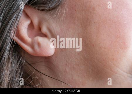 kaukasische reife Frau mit schmerzhaftem Ohr Nahaufnahme, Hörverlust, Ohrbeschwerden, Hörtest, Frauengesundheit, akute Otitis Media, Behandlung und CAR Stockfoto