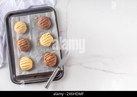 Kochen, das traditionelle mexikanische conchas-Gebäck, Kekse oder Brotbrötchen zubereitet. Hausgemachte Zubereitung von conchas-Dessertgebäck, auf Backblech mit Menschenhand Stockfoto