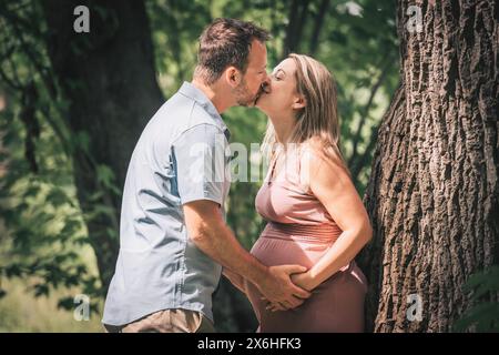 Familie im Sommerpark zusammen. Frau ist schwanger Stockfoto