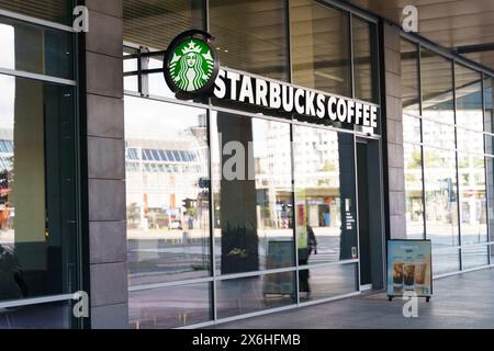 Breslau, Polen - 4. August 2023: Ein modernes Starbucks-Café mit Glasfenstern in einer belebten Stadtstraße. Die Ansicht durch die Fenster wird angezeigt Stockfoto