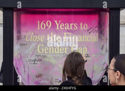 London, Großbritannien. Mai 2024. Frauen unterzeichnen eine große Sanduhr am Trafalgar Square, Teil einer Kampagne von Female Invest, die darauf abzielt, die finanzielle geschlechtsspezifische Kluft zu schließen. Nach Angaben der Organisation wird es derzeit 169 Jahre dauern, um die Lücke zu schließen, und sie ermutigen Frauen, in den Aktienmarkt einzusteigen, um den Wandel zu beschleunigen. Quelle: Vuk Valcic/Alamy Live News Stockfoto