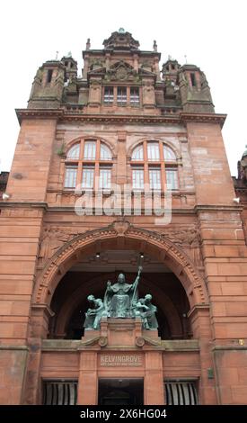 St. Mango-Statue; Kelvin Grove Art Gallery and Museum, Glasgow, Schottland, Großbritannien - St. Mungo ist der Schutzpatron von Glasgow. Zwei Frauen - eine liest A Stockfoto