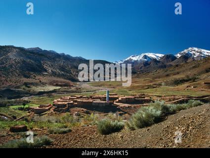 Häuser und Minarett einer Siedlung (möglicherweise Talattane) im Atlasgebirge, Marokko, gesehen von der P1506 Straße, die von der N9 nach Telouet Kasbah führt. Stockfoto