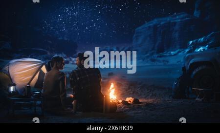 Glückliches Paar Natur Camping im Canyon, zusammen am Lagerfeuer sitzen, reden, Nachthimmel beobachten. Zwei Reisende junge Leute auf inspirierendem Urlaubsausflug bewundern Sie die Milky Way Stars Stockfoto