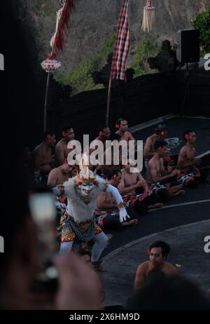 Touristen beobachten den traditionellen balinesischen Kecak-Tanz im Uluwatu-Tempel auf Bali, Indonesien. Stockfoto