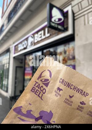 London, Großbritannien. Mai 2024. Das Taco Bell-Logo ist auf der Verpackung eines Crunchwrap vor einer Filiale der Kette in London zu sehen. Die US-amerikanische Fastfood-Kette Taco Bell expandiert in den deutschen Markt. Das erste Restaurant wird diesen Sommer in Berlin eröffnet, weitere folgen. Quelle: Julia Kilian/dpa/Alamy Live News Stockfoto