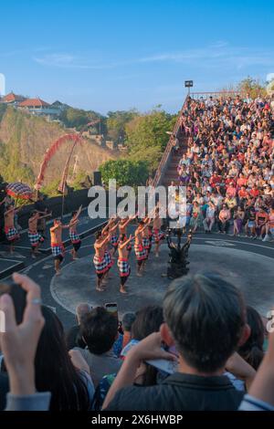 Touristen beobachten den traditionellen balinesischen Kecak-Tanz im Uluwatu-Tempel auf Bali, Indonesien. Stockfoto