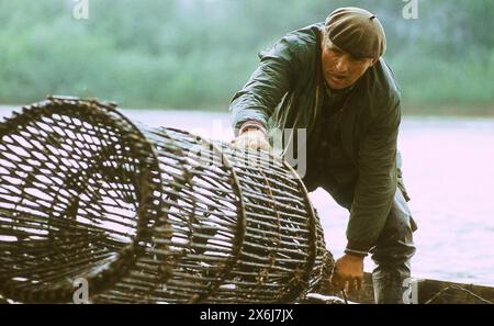 Die Sozialistische Republik Rumänien in den 1970er Jahren Fischer auf einem Holzboot, der Fische mit einer großen Trichterfalle fängt. Stockfoto