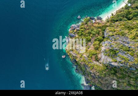 Blick von oben auf ein traditionelles philippinisches Boot segelt im Meer mit klarem und türkisfarbenem Wasser bei Sonnenuntergang. Palawan, Philippinen Stockfoto