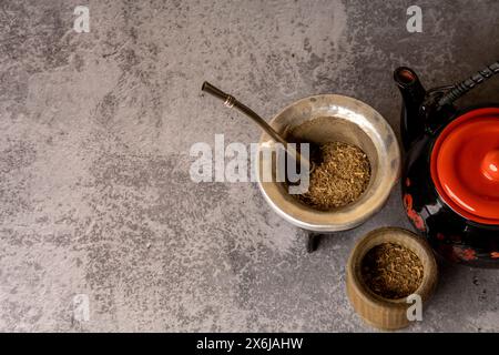 Gesundes infundiertes Getränk, klassischer Yerba Mate Tee in Kürbis mit Bombilla und Gras auf hellgrauem Hintergrund. Stockfoto