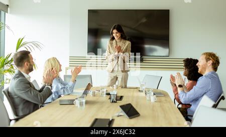Die kompetente Frau präsentiert sich während eines Meetings vor Kollegen, wobei ihr Ausdruck Begeisterung und Führungsstärke zum Ausdruck bringt Stockfoto