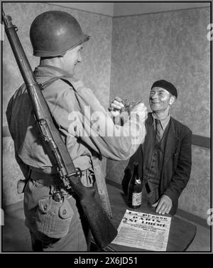 WW2 Frankreich Befreiung August 1944 GI Pvt John Simms toast den Franzosen Louis Lehaut, der eine typische Baskenmütze trägt, mit einer Brille aus feinem Cognac. Eine französische Zeitung im Vordergrund mit der Nachricht, dass Paris von den Nazis befreit wurde. Cherbourg Normandie Frankreich Stockfoto