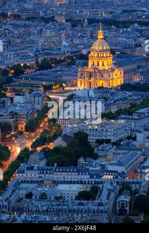 Blick aus der Vogelperspektive auf die goldene Kuppel des beleuchteten Invalidendenkmals, das sich am Abend über Dächern erhebt. Linkes Ufer, Paris, Frankreich Stockfoto