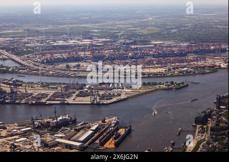 Hamburg, Deutschland. Mai 2024. Blick über die Elbe in den Hamburger Hafen mit der Werft Blohm Voss (im Vordergrund), der Klärschlammverbrennungsanlage VERA von Hamburg Wasser auf dem Köhlbrand-Deich (M) und Containerterminals (aus der Vogelperspektive). Quelle: Christian Charisius/dpa/Alamy Live News Stockfoto