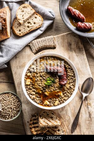 Linsen- und Kartoffeleintopf mit Wurst und Brot Stockfoto