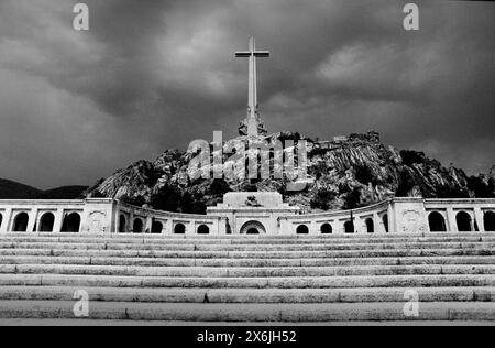 Spanien Tal der gefallenen Sierra de Guadarrama 1987 gescannt 2024 erhebt sich eine der größten Basiliken der Welt über dem Tal zusammen mit dem höchsten Gedenkkreuz der Welt. Die Basílica de la Santa Cruz del Valle de los Caídos (Basilika des Heiligen Kreuzes im Tal der Gefallenen) ist aus einem Granitrücken gehauen. Das 150 Meter hohe (500 Fuß) Kreuz ist aus Stein gebaut. Das Tal von Cuelgamuros (Spanisch: Valle de Cuelgamuros), früher bekannt als Tal der Gefallenen (Spanisch: Valle de los Caídos), ist ein Denkmal in der Sierra de Guadarrama in der Nähe von Madrid. Im Tal befindet sich ein katholischer BA Stockfoto