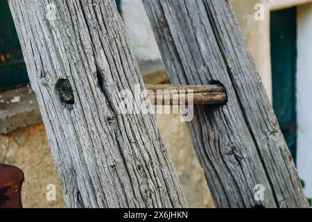 Alte Holzleiter, die an die Wand des Hauses gelehnt ist Stockfoto