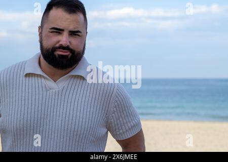 Das Bild fängt einen 30-jährigen Mann in einem Moment der ruhigen Besinnung am Meer ein. Stockfoto