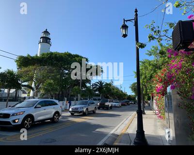 Key West, Florida, 12. Februar 2020: Der Verkehr verläuft neben dem berühmten Leuchtturm, antiken Laternen und farbenfrohen Blumendekorationen an der Truman Avenue in Key West Stockfoto