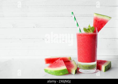 Erfrischendes Wassermelonengetränk in Schichten. Seitenansicht vor weißem Holzhintergrund. Sommeressen. Stockfoto