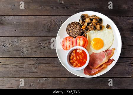 Komplettes schottisches Frühstück mit Haggis. Blick von oben über einen rustikalen dunklen Holzhintergrund. Stockfoto