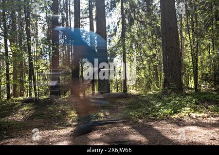 Verschwommenes Bild eines Mannes auf dem Mountainbike auf der Forststraße während des MTB-Radmarathons in Sigulda, Gauja-Nationalpark, Lettland am 12. Mai 2024 Stockfoto