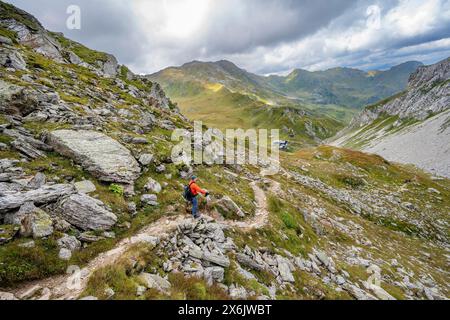 Bergsteiger auf einem Wanderweg hinunter zur Obstanserseehuette, zum Karnischen Hauptkamm, zum Karnischen Höhenweg, zu den Karnischen Alpen, Kärnten, Österreich Stockfoto