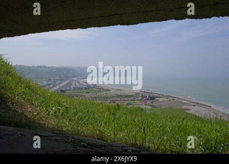 Veulettes-sur-Mer, Frankreich - 10. Mai 2024: Blick von Veulettes-sur-Mer aus einem Bunker auf dem Hügel. Leute, die in der Stadt Veulettes-sur-Mer laufen. Stockfoto