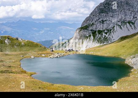 Obstanserseehuette und Bergsee Obstansersee zwischen grünen Bergwiesen, Karnischen Hauptkamm, Karnischen Höhenweg, Karnischen Alpen, Kärnten Stockfoto