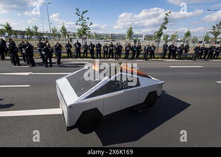 Ein Cybertruck-Pappmodell vor dem Fabrikgelände, bewacht von Polizisten während der Demonstration Wasser. Wald. Gerechtigkeit gegen die Stockfoto