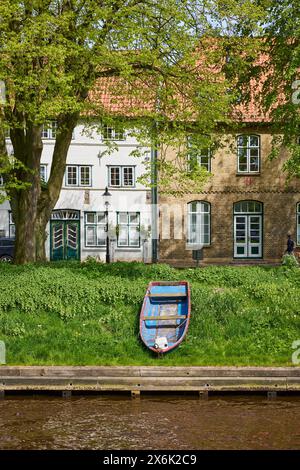 Altes Holzboot und historische Häuser am Mittelburggraben in Friedrichstadt, Nordfriesland, Schleswig-Holstein Stockfoto