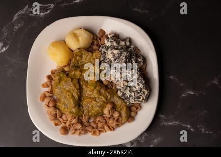 Traditionelles bolivianisches Essen namens 'Fauch conejo' (falsches Kaninchen), auf schwarzem Tisch Stockfoto