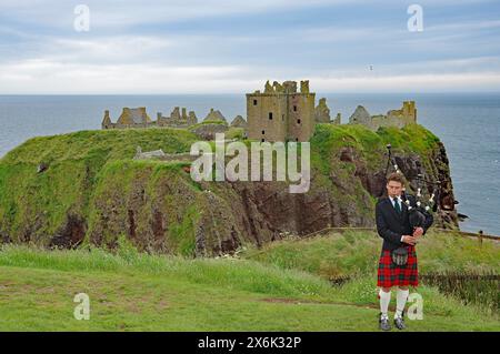 Sackpiper vor den Ruinen von Dunnottar Castle, schlossähnliches Gebäude auf einer Klippe, Stonehaven, Schottland, Großbritannien Stockfoto