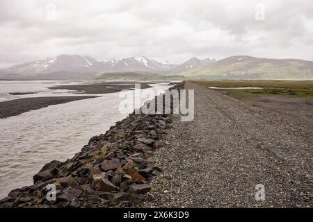 Schotterstraße in der Nähe des Flusses und des Ozeans in der Gegend von Stafafell in Island Stockfoto