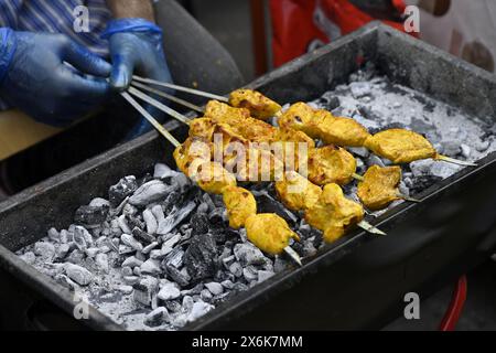 Hähnchenstücke auf Spießen, die über Holzkohlegrill gekocht werden Stockfoto